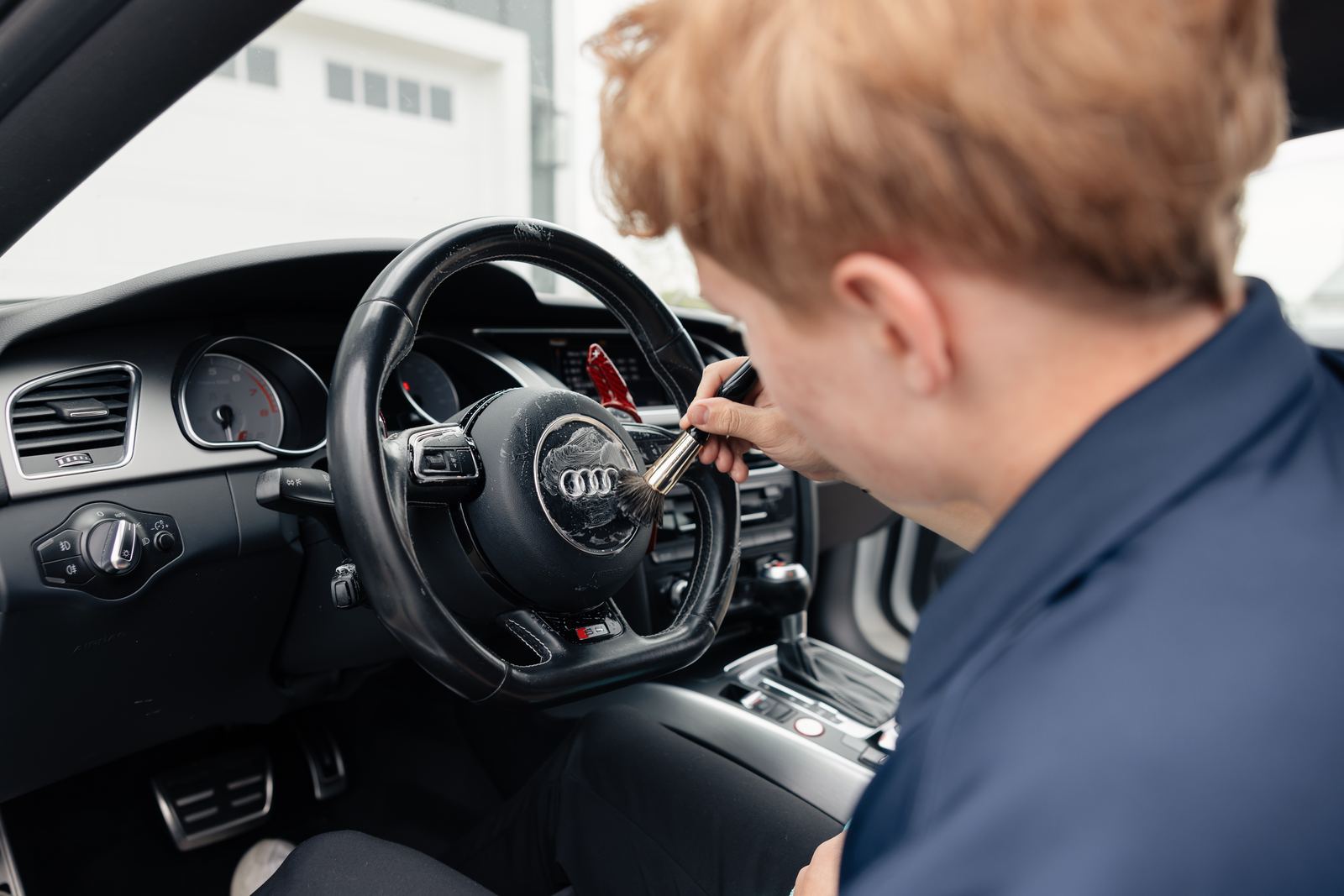 Detailer cleaning steering wheel